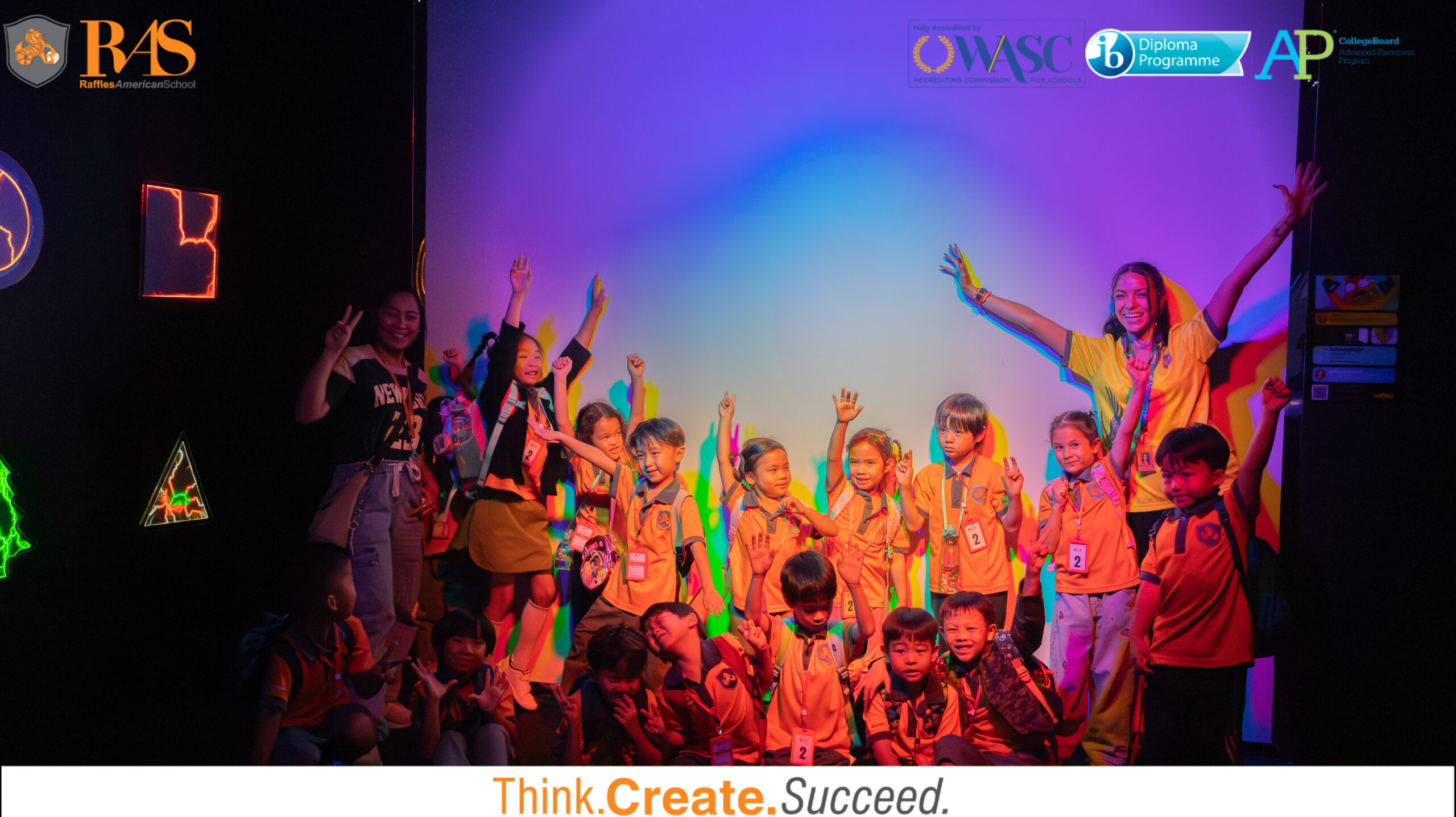RAS K3 students in bright orange uniforms posing for a group photo during their science field trip at WOW Park, Gateway Ekkamai.